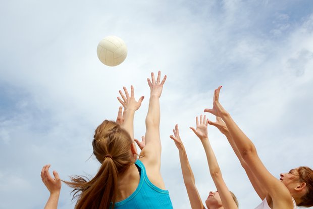 Volleyballspielerin strecken sich nach dem Ball 